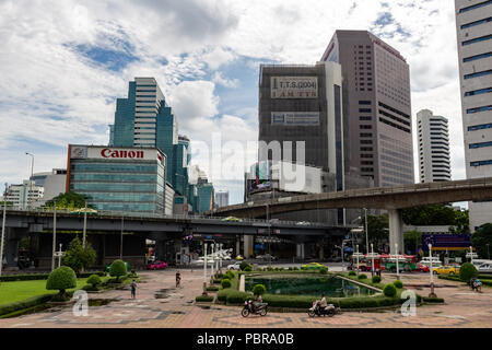 Bangkok, Thailand - 1. Mai 2018: verkehrsreichen Kreuzung zwischen Silom Skytrain Station und Lumphini Park von Wolkenkratzern umgeben Stockfoto