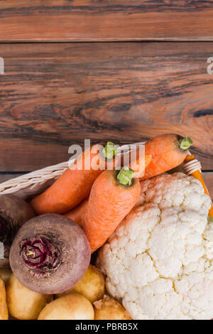 Gemüse Warenkorb auf Holz mit Copyspace. Schreibtisch aus Holz Tisch Hintergrund. Stockfoto