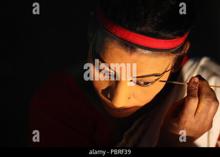 Ein Kutiyattam Künstler bereiten sich auf die Leistung, indem Sie Gesicht Farbe. Artist computing Gesicht painint, Kutiyattam Künstler bereit. Stockfoto