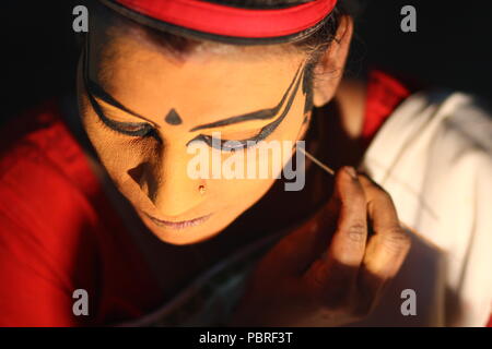 Ein Kutiyattam Künstler bereiten sich auf die Leistung, indem Sie Gesicht Farbe. Artist computing Gesicht painint, Kutiyattam Künstler bereit. Stockfoto