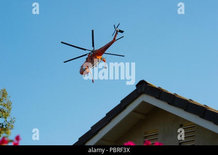 Fallbrook, Kalifornien, USA - 29. Juli 2018: CalFire Hubschrauber kreisen wildfire, wie es bereitet Wasser auf das Feuer in der Nähe von Fallbrook, Kalifornien in San zu fallen Stockfoto