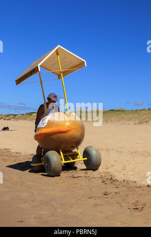 Donut Verkäufer drücken ein Donut geformt Essen Warenkorb mit großen Rädern entlang dem Strand an einem sonnigen Tag in Sao Martinho Portugal Stockfoto