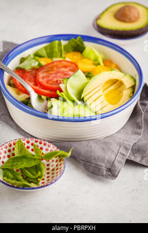 Grüne Zucchini nudeln Salat mit Tomaten, Avocado und Basilikum. Gesund vegan Zucchini Pasta. Saubere Konzept essen. Stockfoto