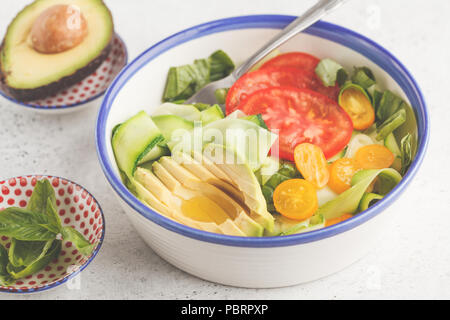 Grüne Zucchini nudeln Salat mit Tomaten, Avocado und Basilikum. Gesund vegan Zucchini Pasta. Saubere Konzept essen. Stockfoto