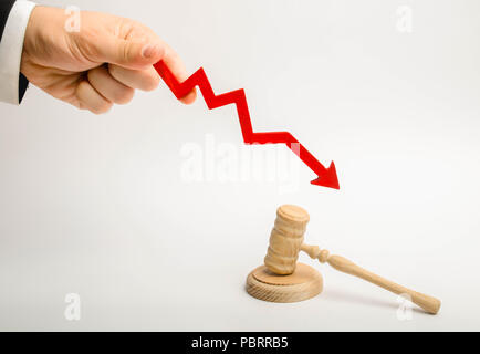Die hand hält die Scrolltaste mit Pfeil nach unten in der Nähe des Richters Hammer. Das Konzept reduziert den Anteil der Offenlegung von Strafsachen, Absenken der Prozentsatz der Stockfoto