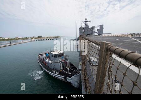 180728-N-GX 781-0009 MARINESTATION Guantánamo Bay, Kuba (28. Juli 2018) eine Tug Boat unterstützt die Whidbey Island-Class Dock Landung Schiff USS Gunston Hall (LSD 44) als das Schiff kommt in der Marinestation Guantánamo Bay, Kuba für einen geplanten Hafen besuchen. Die Gunston Hall ist auf die Bereitstellung unterstützen, Südsee, das ist eine jährliche gemeinsame Bereitstellung in der US Southern Command Verantwortungsbereich, wo eine Aufgabengruppe bereitstellen werden eine Vielzahl von Übungen und multinationalen Austausch durchzuführen, die Interoperabilität zu verbessern, die regionale Stabilität zu erhöhen und regionale Beziehungen aufbauen und pflegen wi Stockfoto