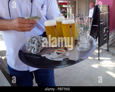 Kellner bringt Trinken um den Tisch im Cafe in Frankreich Stockfoto