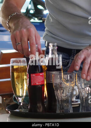 Kellner bringt Trinken um den Tisch im Cafe in Frankreich Stockfoto