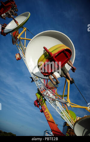 Die Passagiere genießen die Fahrt mit dem tilt-a-whirl beim Karneval in Apollo Bay. Stockfoto