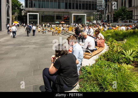 Arbeitnehmer und Touristen entspannen am Mittag in St. Helen's Square, einem öffentlichen Platz vor der St. Helen's Wolkenkratzer und die Leadenhall Building Stockfoto