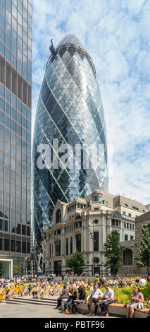 The Gherkin/30 St Mary Axe, und St Helen's Turm über Fitzwilliam Haus und lokale Mitarbeiter und Besucher entspannen in St. Helen's Square. Stockfoto