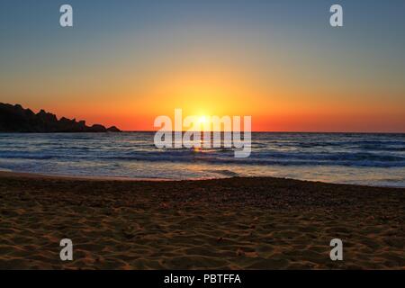 Schönen Sonnenuntergang auf einer abgeschiedenen Mediterranen Sandstrand in Ghajn Tuffieha (Riviera Bay), Malta Stockfoto