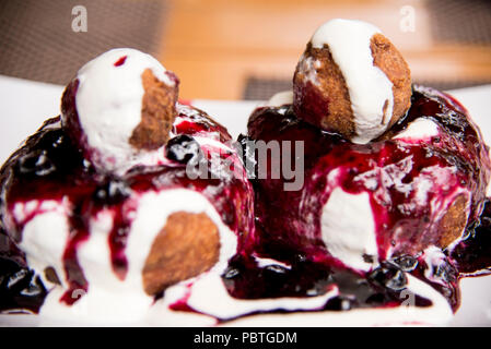 Papanasi - eine traditionelle rumänische Dessert. Der Kuchen wird von drei Donuts in der sauren Sahne und Früchten Marmelade gemacht Stockfoto