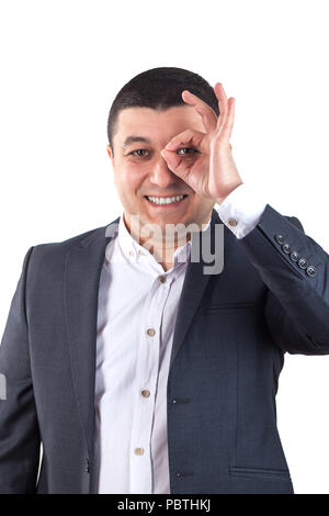 Porträt der jungen Mann in einem weißen Hemd und schwarzen Anzug und zeigt ein Zeichen ok. Auf weiß isoliert. Stockfoto