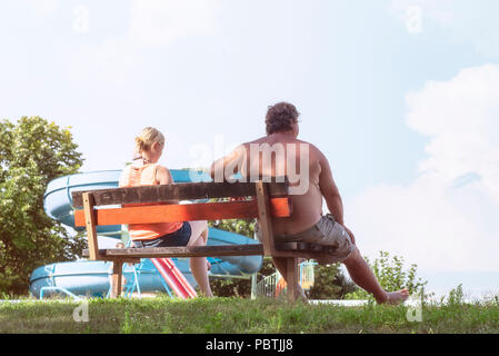 Ein Mann und eine Frau sitzen auf einer Bank in einem Park Stockfoto