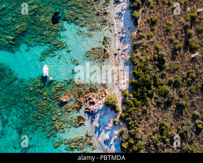 Blick von oben Luftbilder von einem Schlauchboot mit einige entspannte Touristen an Bord vor Anker in der transparenten und das türkisfarbene Meer der Costa Smeralda Stockfoto
