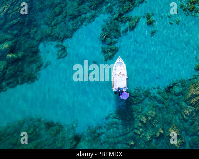 Blick von oben Luftbilder von einem Schlauchboot mit einige entspannte Touristen an Bord vor Anker in der transparenten und das türkisfarbene Meer der Costa Smeralda Stockfoto