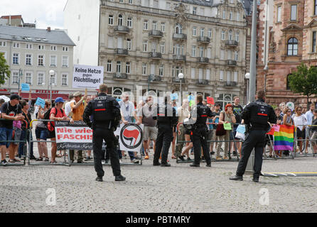 Wiesbaden, Deutschland. 29. Juli, 2018. Die Demonstranten werden von Polizisten aus dem rechten Flügel Protest getrennt. Rechtsextreme Demonstranten der Hand in Hand-Gegen die Gewalt in unseren Strasen (Hand in Hand - gegen Gewalt auf unseren Straßen) Bewegung statt einer regierungsfeindlichen Kundgebung in Wiesbaden. Dieser Protest war unter dem Vorwand, eine Mahnwache für den Jugendlichen Susanna F, der angeblich von einem Flüchtling in Wiesbaden getötet wurde. Die Kundgebung wurde von mehreren Anti-government Referenten, die forderte, dass die Regierung zum Rücktritt gerichtet. Quelle: Michael Debets/Pacific Press/Alamy leben Nachrichten Stockfoto