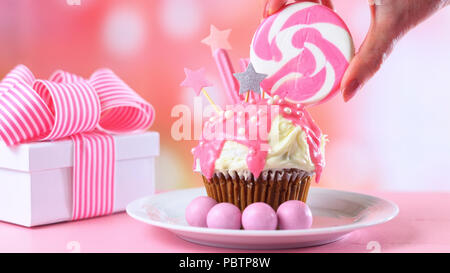 Pink Thema bunte Neuheit Cupcake mit Süßigkeiten und großen herzförmigen Lollipop für Kinder und jugendlich Geburtstag, zum Valentinstag oder Muttertag Da Stockfoto