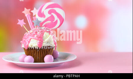 Pink Thema bunte Neuheit Cupcake mit Süßigkeiten und großen herzförmigen Lollipop für Kinder und jugendlich Geburtstag, zum Valentinstag oder Muttertag Da Stockfoto