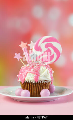 Pink Thema bunte Neuheit Cupcake mit Süßigkeiten und großen herzförmigen Lollipop für Kinder und jugendlich Geburtstag, zum Valentinstag oder Muttertag Da Stockfoto