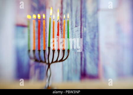 Menorah mit Kerzen für Chanukka gegen defokussierten Lichter, Nahaufnahme Stockfoto