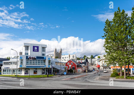 Akureyri, Island - 17. Juni 2018: Straße Stadtbild in der Stadt Dorf Stadt mit Menschen, Kirche, Straße, Bürgersteig, Blick auf die schneebedeckte Berg im Sommer Stockfoto