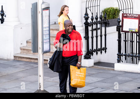 London, Großbritannien, 22. Juni 2018: Nachbarschaft Stadtteil South Kensington Mann, Sainsbury's Supermarkt Einkaufstaschen warten Straße überqueren, Bushaltestelle Stockfoto