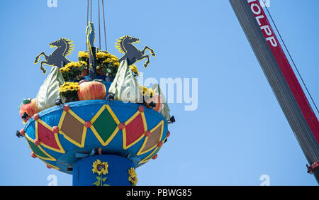 Stuttgart, Deutschland. 30. Juli, 2018. Ein Kran montiert die Spalte "Obst" am Cannstatter Wasen Festival. Die Spalte ist ein traditionelles Symbol der Dankbarkeit für die Ernte und das Herzstück des Cannstatter Messe. In diesem Jahr wird das Festival am 28. September und endet am 14. Oktober. Credit: Sebastian Gollnow/dpa/Alamy leben Nachrichten Stockfoto