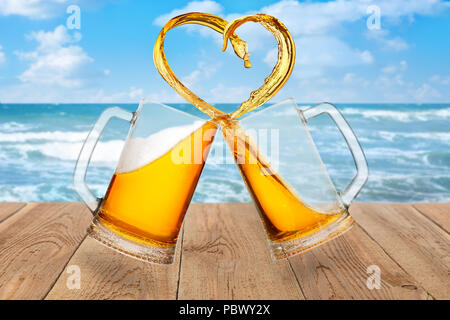 Liebe zu Bier Konzept. Zwei Glas Becher Toasten und Erstellen von Splash in Herzform auf Meer Hintergrund Stockfoto