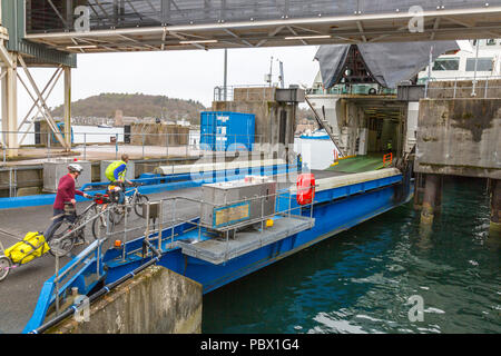 Zwei Radfahrer einem Fährschiff für Barra auf den Äußeren Hebriden an der CalMac Ferry Terminal in Oban, Argyll und Bute, Schottland, Großbritannien Stockfoto