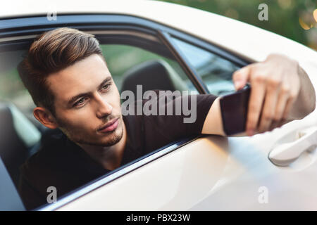 Passagier Geschäftsmann mit einem Smartphone auf dem Rücksitz des Autos. Stockfoto