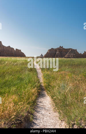 Schmutz engen Trail schlängelt sich durch Feld mit Badlands Bildung Stockfoto