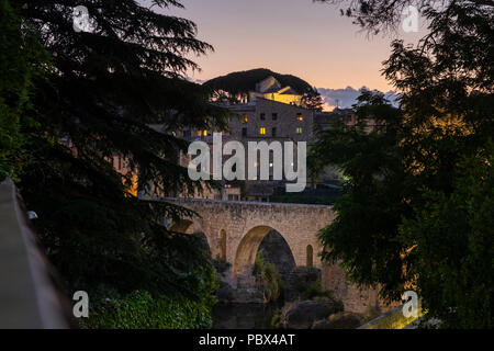 Die romanische Brücke über den Fluss Fluvia und die Stadt bei Nacht in Besalu, Garrotxa, Katalonien, Spanien leuchtet Stockfoto