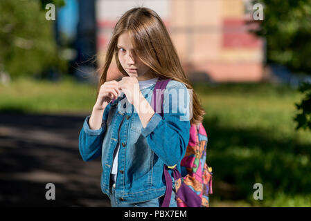 Mädchen Schulmädchen. Sommer in der Natur. Es ist im Rack. Ich bin bereit, einen Kampf zu beginnen. Das Konzept für den Schutz von Kindern, attack Konflikte, Widerstand Probleme. Emotion von Mut und Selbstvertrauen. Stockfoto