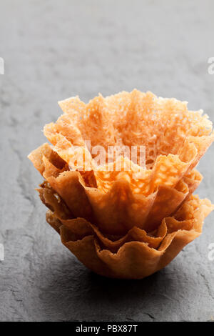 Brandy snap Körbe auf schwarzen Stein Hintergrund Stockfoto