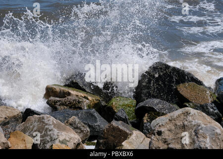 Konzept close up Bilder von Wellen waschen über Felsen und Spritzwasser aus den Felsen am Meer mit Licht reflektiert sie das Wasser und die Felsen. Stockfoto