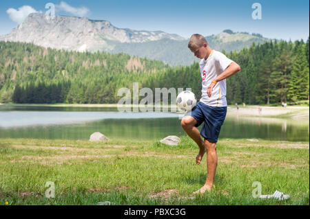 Fußball-Spieler jongliert den Ball in der Natur Stockfoto