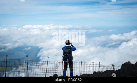 Bergsteiger über den Wolken vom Gipfel des Mount Fuji in Japan suchen Stockfoto