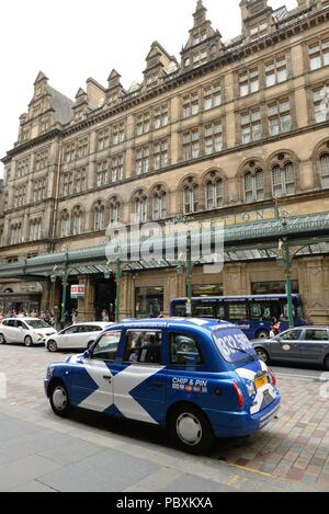 Die blauen und weißen saltire Fahne ziert ein Taxi am Haupteingang Hauptbahnhof von Glasgow in Schottland, Großbritannien und das Central Hotel. Stockfoto