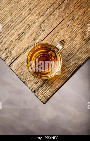 Ansicht von oben Glas Tasse Tee auf hölzernen Tisch Stockfoto