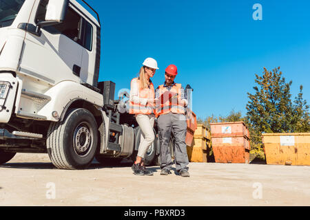 Arbeitnehmer Unterzeichnung Papiere zu Abbruch Container geliefert Stockfoto