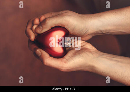Rotes Herz in den Händen des Menschen, Ansicht von oben Stockfoto