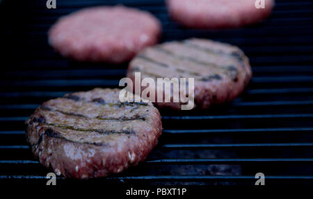 Beefburgers kochen auf BBQ Stockfoto