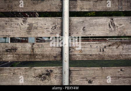 Details einer alten hölzernen Zaun mit einem Metallstab in der Mitte. Stockfoto