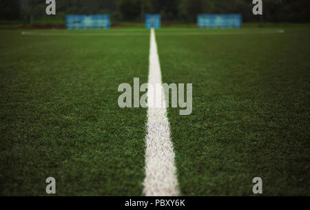 Detailansicht auf frisches Gras von einem Fußball-yard, Bänke für Spieler in verschwommenen Hintergrund. Stockfoto