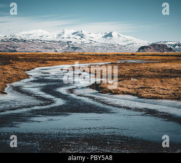 Island typischen Berg winter Szene mit Gras im Vordergrund und massiven Berg im Hintergrund. Stockfoto