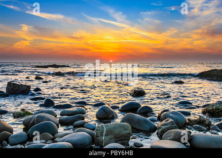 Dramatischer Sonnenuntergang über dem Meer in Westward Ho!, Devon, Großbritannien Stockfoto