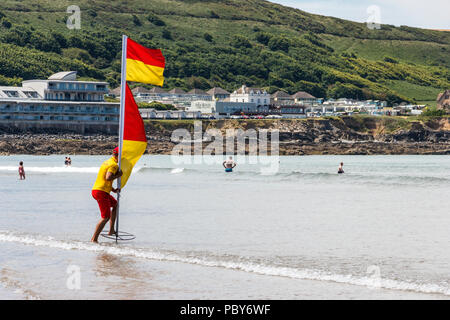 RNLI Rettungsschwimmer Setzen einer Markierung Markierung in der Strand in Westward Ho!, Devon, Großbritannien Stockfoto