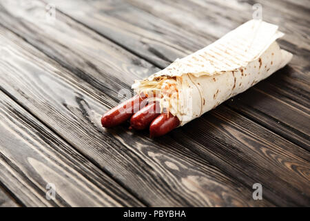 Hausgemachte Wurst in pita Brot auf hölzernen Hintergrund. Foto mit Stockfoto